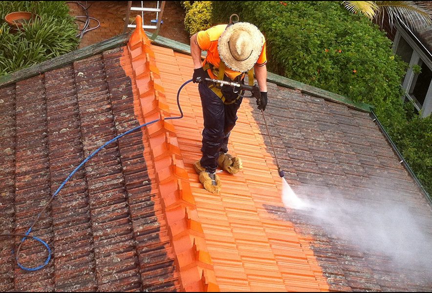 pressure washing technician cleaning roof tiles