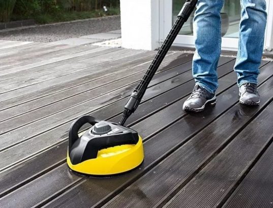 soft wash technician cleaning a wooden deck